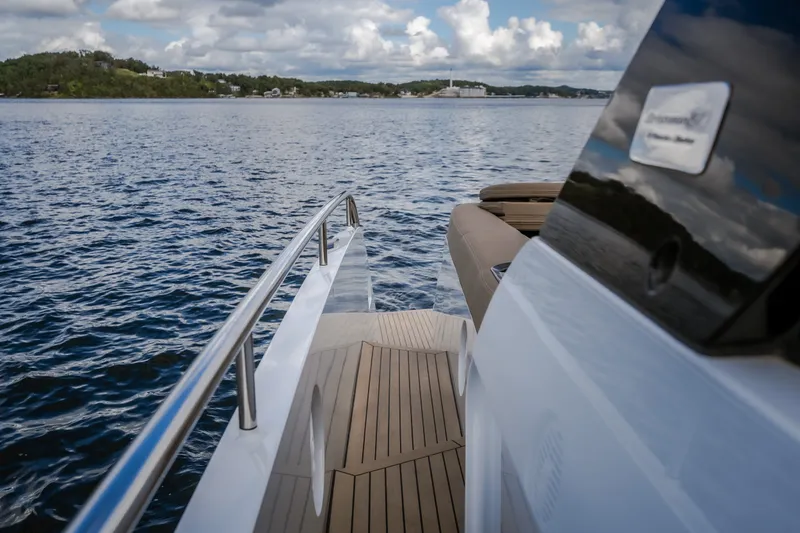 Slide: The Image of 2022 Steeler Bronson 50 yacht cruising on a serene lake under a cloudy sky. - 58