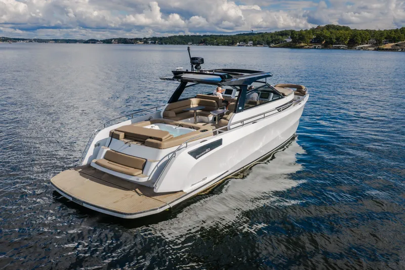 Slide: The Image of 2022 Steeler Bronson 50 yacht cruising on a serene lake under a cloudy sky. - 2