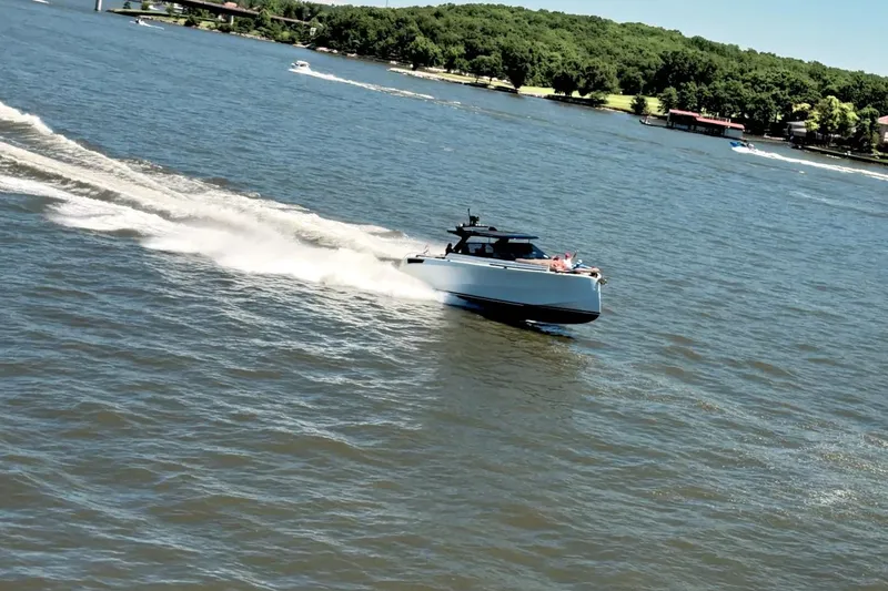Slide: The Image of 2022 Steeler Bronzon 50 yacht cruising on a scenic lake with lush green shoreline. - 8