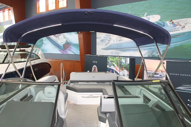 Slide: The Image of 2023 Cobalt R8 boat interior with blue canopy, displayed in showroom setting. - 31