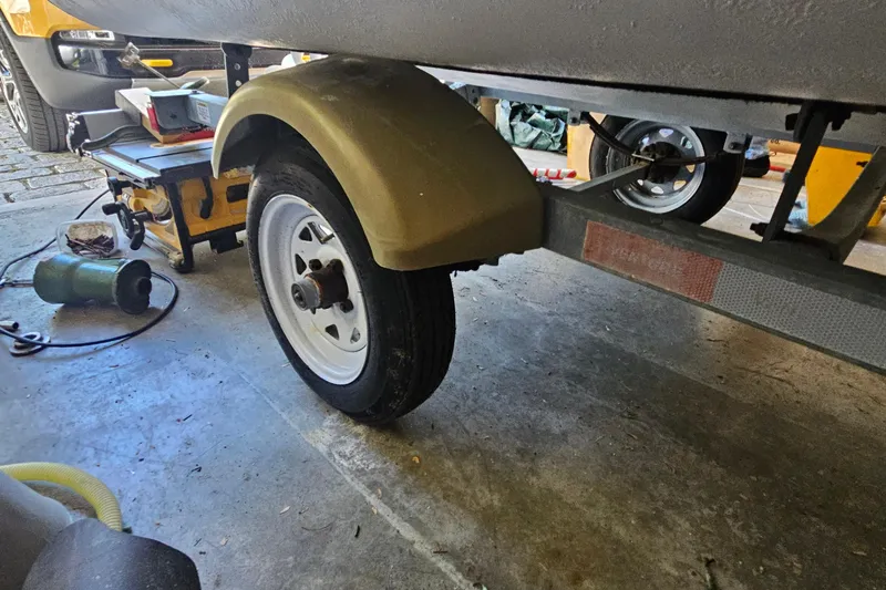 Slide: The Image of Trailer wheel of a 2014 Zodiac Yachtline 2 Deluxe 380 in a garage setting. - 12