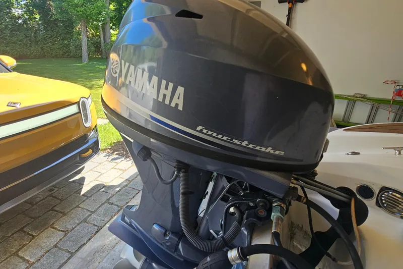 Slide: The Image of Yamaha four-stroke engine on 2014 Zodiac Yachtline 2 Deluxe 380, parked beside a yellow vehicle. - 6