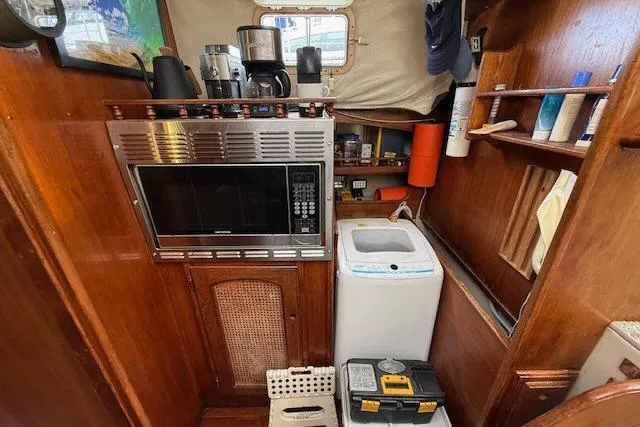 Slide: The Image of Interior of 1982 Lancer 45 Motorsailer with microwave, washing machine, and wooden cabinetry. - 10