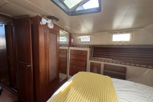 Slide: The Image of Interior of 1982 Lancer 45 Motorsailer with wooden cabinetry and cozy bedding. - 20