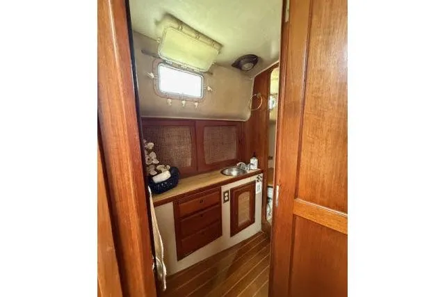 Slide: The Image of 1982 Lancer 45 Motorsailer interior with wooden cabinetry and compact sink area. - 21
