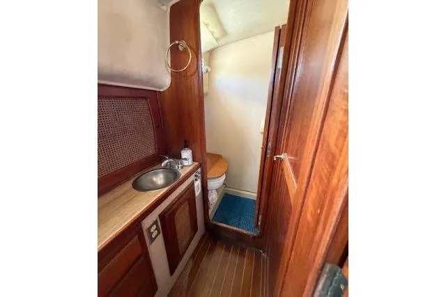 Slide: The Image of 1982 Lancer 45 Motorsailer bathroom with wooden cabinetry, sink, and toilet. - 22