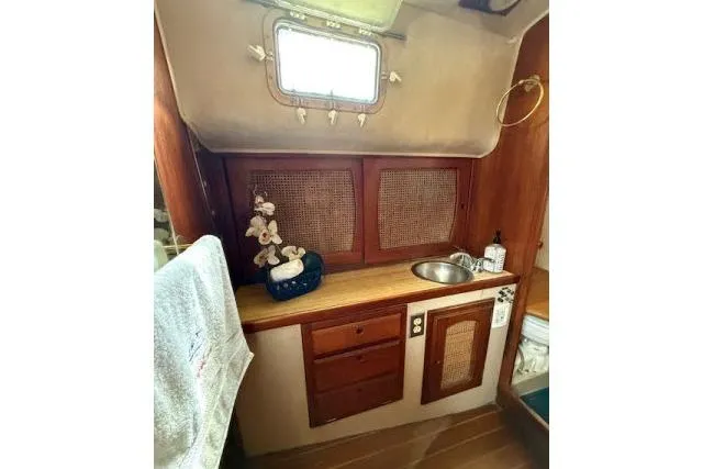 Slide: The Image of 1982 Lancer 45 Motorsailer interior with wooden cabinetry, sink, and decorative elements. - 23