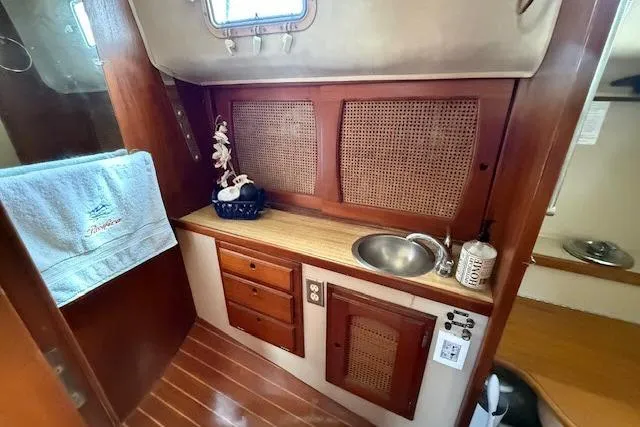 Slide: The Image of Interior of 1982 Lancer 45 Motorsailer with wooden cabinetry and compact sink area. - 24