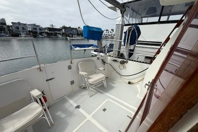 Slide: The Image of 1982 Lancer 45 Motorsailer deck with seating, overlooking marina and waterfront homes. - 26