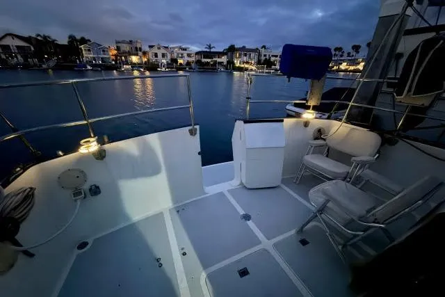 Slide: The Image of Cockpit view of 1982 Lancer 45 Motorsailer at dusk, overlooking serene waterfront homes. - 27