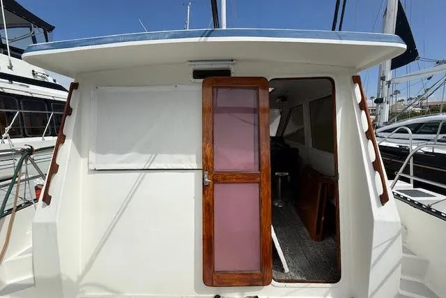 Slide: The Image of 1982 Lancer 45 Motorsailer with wooden door, docked at marina. - 31
