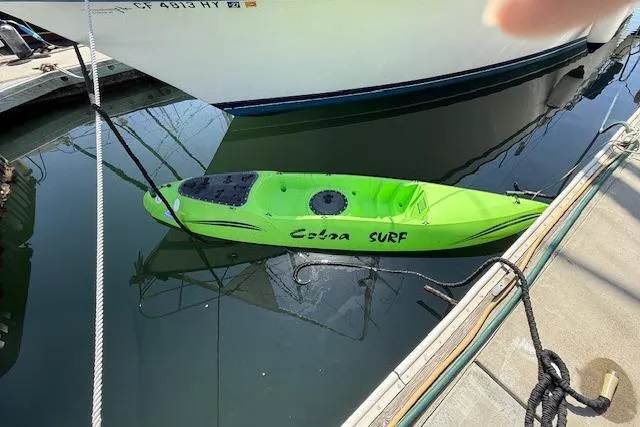 Slide: The Image of Bright green Cobra Surf kayak docked beside a Lancer 45 Motorsailer, 1982 model. - 42