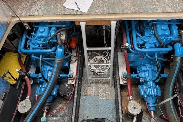 Slide: The Image of Engine room of a 1982 Lancer 45 Motorsailer with dual blue engines and ladder access. - 43