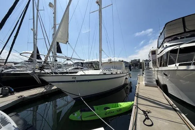 Slide: The Image of 1982 Lancer 45 Motorsailer docked at marina with kayak nearby. - 48