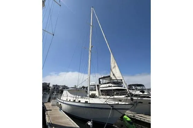 Slide: The Image of 1982 Lancer 45 Motorsailer docked at marina under clear blue sky. - 50