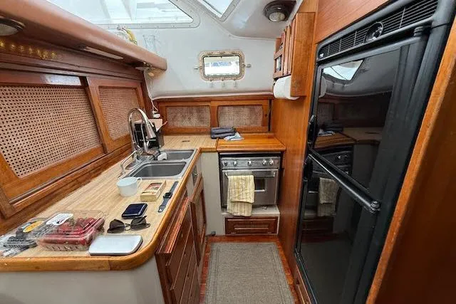 Slide: The Image of Interior of 1982 Lancer 45 Motorsailer kitchen with wooden cabinetry and modern appliances. - 6