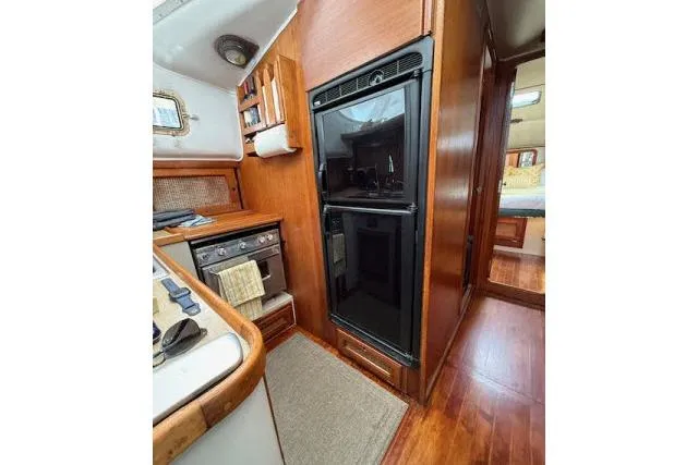 Slide: The Image of 1982 Lancer 45 Motorsailer interior kitchen with wood cabinetry and modern appliances. - 8