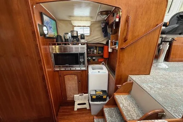 Slide: The Image of Interior of 1982 Lancer 45 Motorsailer with microwave, washing machine, and wooden cabinetry. - 9