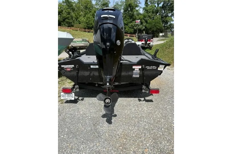 Slide: The Image of 2023 Tracker Pro Team 175 TXW boat with outboard motor, parked on gravel. - 16