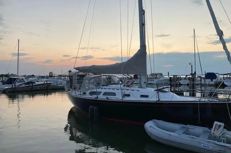 Slide: The Image of Sailboat Sabre 36, 1998 model, docked at sunset in a serene marina. - 1