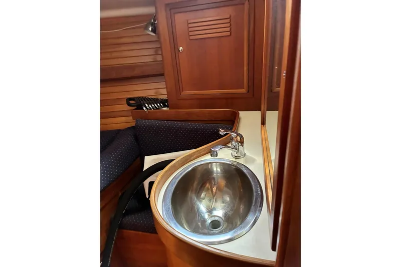 Slide: The Image of Interior of 1998 Sabre 36 yacht featuring a compact sink and wooden cabinetry. - 10