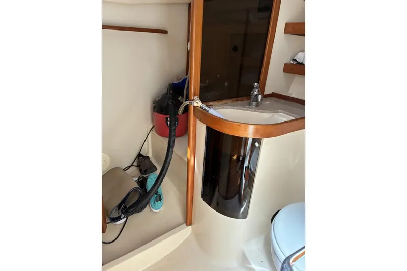 Slide: The Image of Interior of a 1998 Sabre 36 boat featuring a compact sink and storage area. - 11