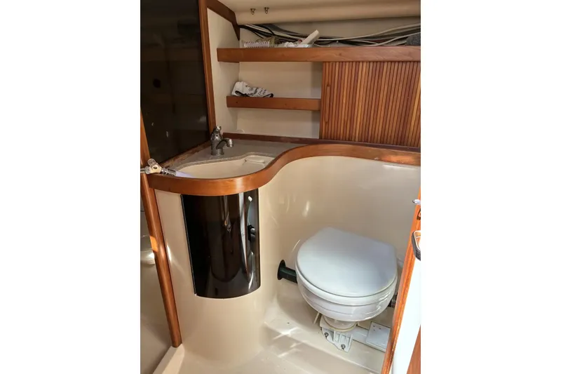 Slide: The Image of 1998 Sabre 36 yacht bathroom with wooden accents and compact design. - 12