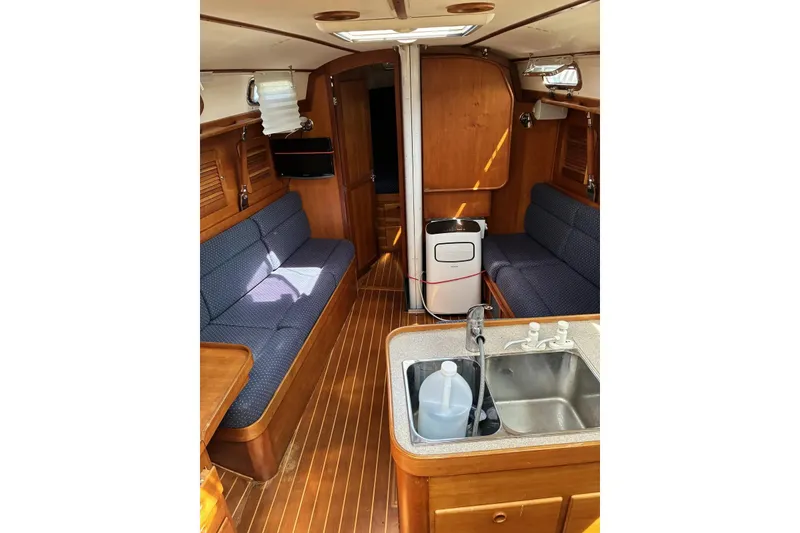 Slide: The Image of Interior of 1998 Sabre 36 sailboat with wooden finish and cozy seating area. - 4