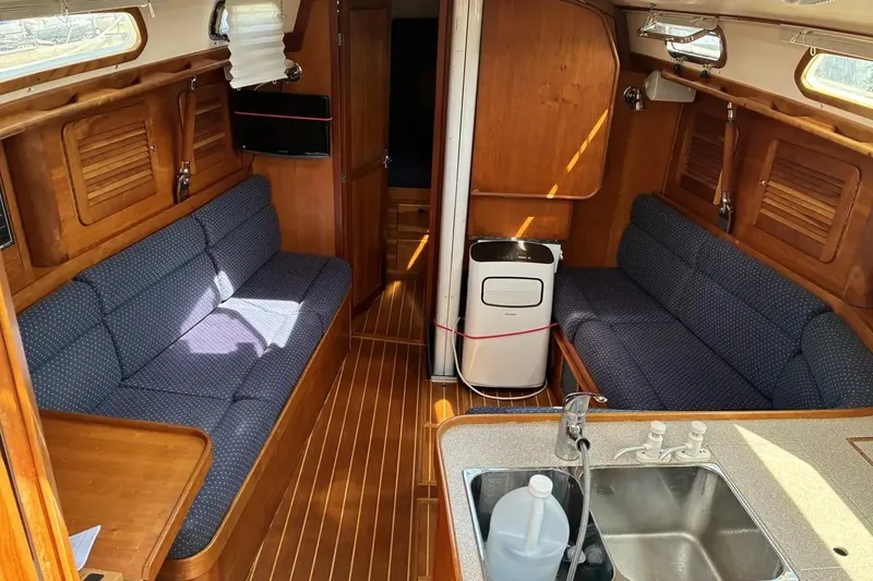 Slide: The Image of Interior of a 1998 Sabre 36 sailboat with wooden finish and blue seating. - 6