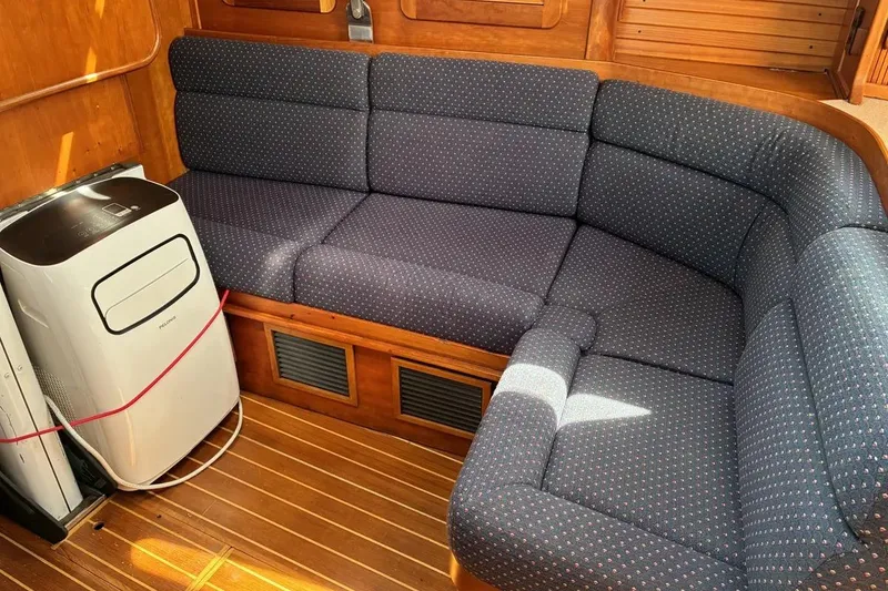 Slide: The Image of Interior of a 1998 Sabre 36 yacht with blue cushioned seating and portable air conditioner. - 7