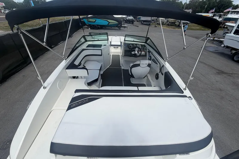 Slide: The Image of 2015 Sea Ray 19 SPX boat interior with seating and steering wheel under canopy. - 11