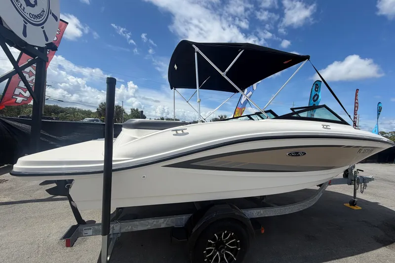 Slide: The Image of 2015 Sea Ray 19 SPX boat with canopy on trailer under blue sky. - 2