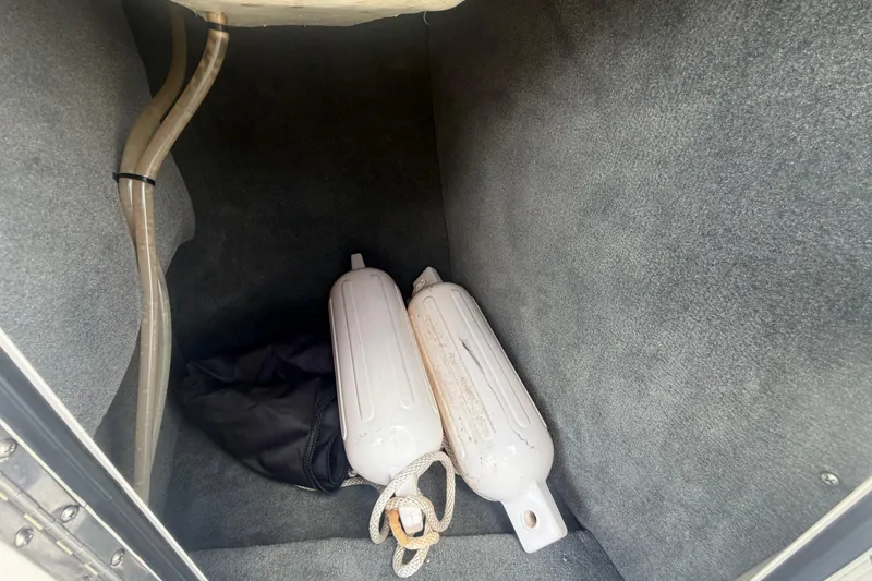 Slide: The Image of Storage compartment of a 2015 Sea Ray 19 SPX with boat fenders and a black bag. - 28