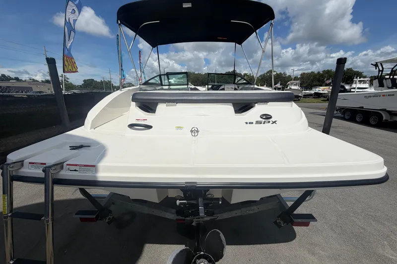 Slide: The Image of 2015 Sea Ray 19 SPX boat with bimini top, displayed outdoors under blue sky. - 3