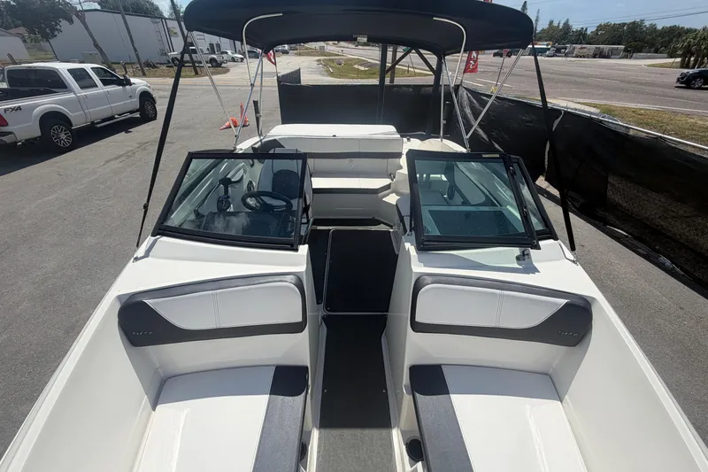 Slide: The Image of 2015 Sea Ray 19 SPX boat interior with seating and windshield, parked outdoors. - 37