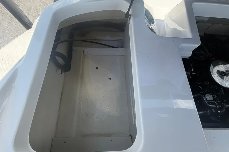 Slide: The Image of Open storage compartment and engine area of a 2015 Sea Ray 19 SPX boat. - 52