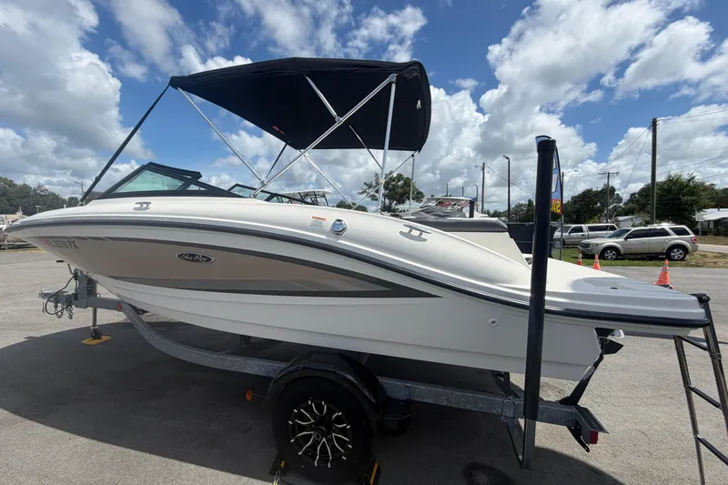 Slide: The Image of 2015 Sea Ray 19 SPX boat with canopy on trailer under cloudy sky. - 6