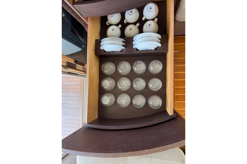Slide: The Image of Elegant wooden cabinet with neatly arranged teacups and saucers on a 2007 Azimut 43S yacht. - 28