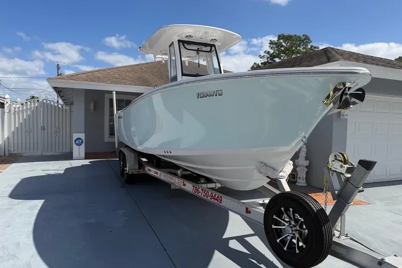 The Image of 2024 Sportsman Heritage 231 Center Console boat on trailer, parked in driveway. - 1