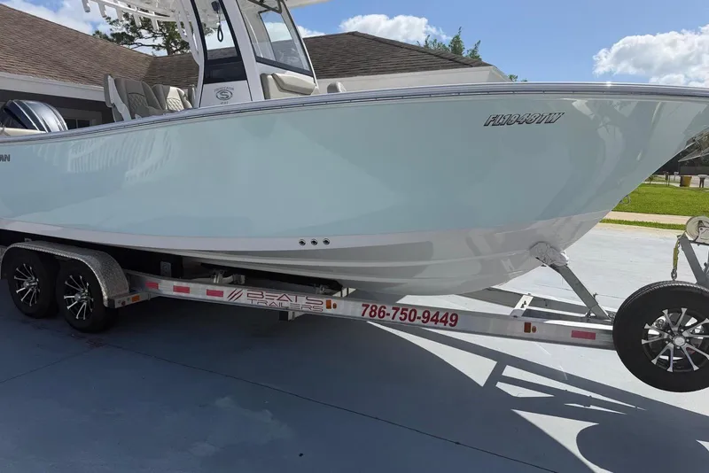 Slide: The Image of 2024 Sportsman Heritage 231 Center Console boat on trailer, parked outdoors. - 2