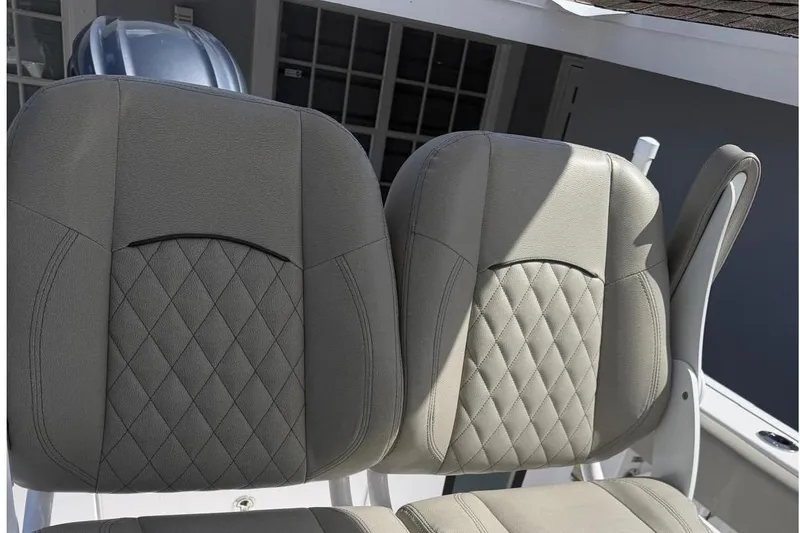 Slide: The Image of 2024 Sportsman Heritage 231 Center Console boat seats with diamond-pattern upholstery. - 9