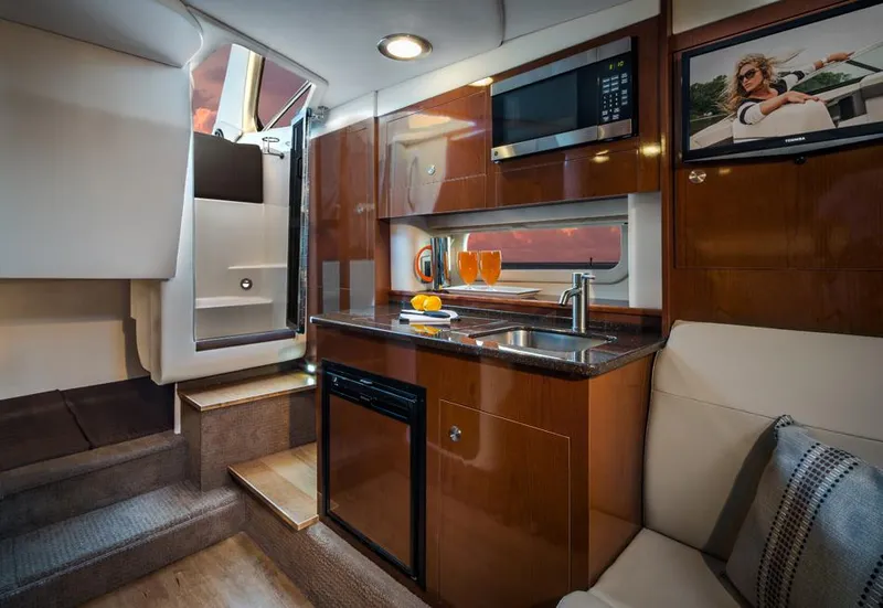 Slide: The Image of Manufacturer Provided Image: 2016 Sea Ray 310 Sundancer interior with kitchenette, microwave, and seating area. - 10
