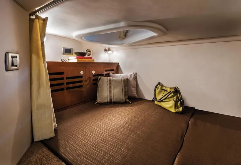 Slide: The Image of Manufacturer Provided Image: 2016 Sea Ray 310 Sundancer cabin interior with bed, pillows, and storage. - 12