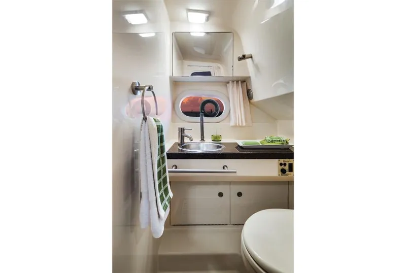 Slide: The Image of Manufacturer Provided Image: 2016 Sea Ray 310 Sundancer bathroom with sink, mirror, and towel rack. - 13