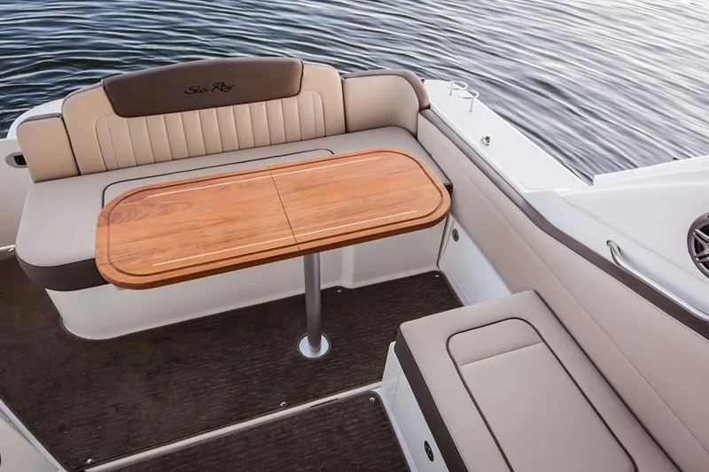 Slide: The Image of Manufacturer Provided Image: 2016 Sea Ray 310 Sundancer boat interior with seating and wooden table. - 7