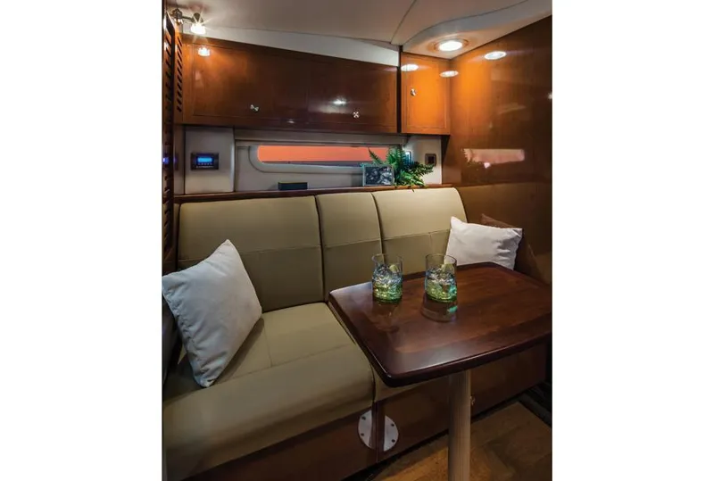 Slide: The Image of Manufacturer Provided Image: Interior of 2016 Sea Ray 310 Sundancer with cozy seating and wooden table. - 9