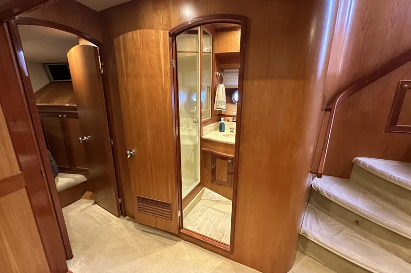 Slide: The Image of Interior of 2004 McKinna 57 PHMY yacht, featuring wood paneling and a compact bathroom. - 85