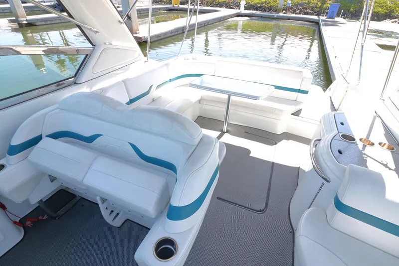 Slide: The Image of 2006 Formula 330 Sun Sport boat interior with white seating and table, docked by water. - 10