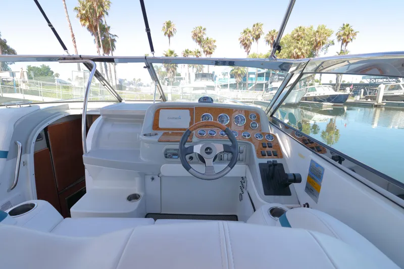 Slide: The Image of 2006 Formula 330 Sun Sport boat cockpit with steering wheel and dashboard, docked near palm trees. - 15