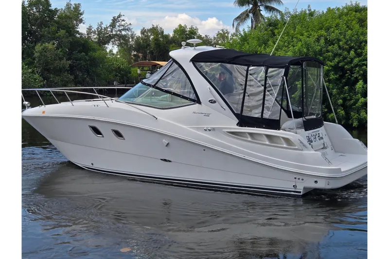 Slide: The Image of 2010 Sea Ray Sundancer 330 yacht cruising on a calm river, surrounded by lush greenery. - 2
